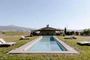 uma piscina em frente a uma casa com duas cadeiras em Locanda in Tuscany em Castiglione dʼOrcia