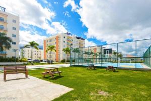a park with two picnic tables and a pool at Full CozyCondo+Private Terrace+BBQ in Punta Cana