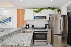 a kitchen with a stainless steel refrigerator and a sink at Full CozyCondo+Private Terrace+BBQ in Punta Cana