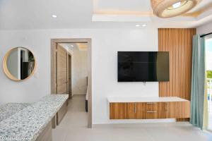 a living room with a flat screen tv on a wall at Full CozyCondo+Private Terrace+BBQ in Punta Cana