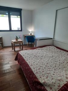 een slaapkamer met een groot bed en een tafel bij Beauté et Fonctionalité aux Portes de Paris in Meudon