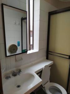 Hotel Sevilla Plaza في بوكارامانغا: حمام مع حوض ومرحاض ومرآة