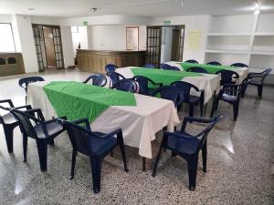 a row of tables and chairs with green table cloth at Hotel Sevilla Plaza in Bucaramanga