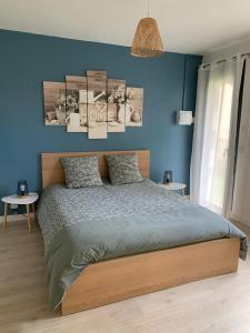 una camera da letto con una parete blu e un letto di gite La briquette 6 personnes proche RER D a Combs-la-Ville