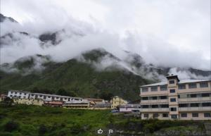 a group of buildings in front of a mountain at OM Kutir Badrinath Dham in Badrīnāth