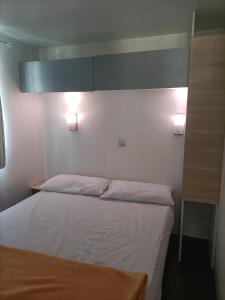 um quarto com uma cama e duas luzes na parede em Camping Relax Sol em Torredembarra