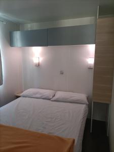 a bedroom with a bed and two lights on the wall at Camping Relax Sol in Torredembarra