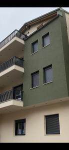 - un bâtiment vert avec des fenêtres et un balcon dans l'établissement Element Suites - Red - Apt 1BD - Kalambaka, à Kalambaka