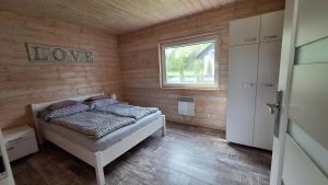 um quarto com uma cama num quarto com uma janela em Domki Komfort całoroczne em Zator