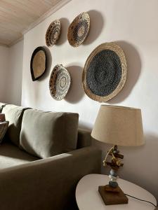 soggiorno con divano e cappelli appesi al muro di Raffar luxury houses Psarou a Platis Yalos