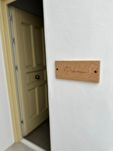 un cartel de madera en la puerta de una habitación en Raffar luxury houses Psarou en Platis Yialos Mykonos