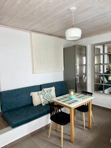 een woonkamer met een blauwe bank en een tafel bij Raffar luxury houses Psarou in Platis Yialos Mykonos