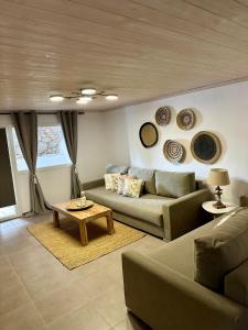 sala de estar con sofá y placas en la pared en Raffar luxury houses Psarou en Platis Yialos Mykonos
