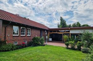 a brick house with a lawn in front of it at Ferienhaus im Moor in Wiesmoor