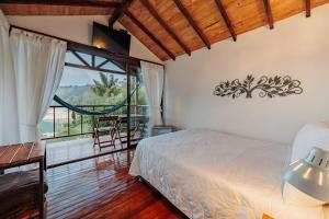 1 dormitorio con cama y ventana grande en Hotel Pietrasanta, en Guatapé