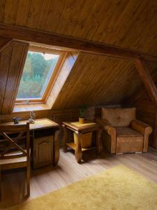 a room with a chair and a table in a attic at Kamień i Sowa in Lipinki Łużyckie