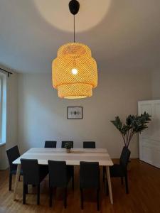 einen Esstisch mit Stühlen und einer Leuchte in der Unterkunft 90 m2 Spacious Apartment - 15 min to Center in Wien