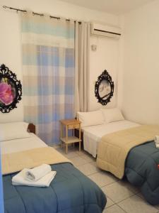 a bedroom with two beds and a table and a mirror at Frini Apartments and Studios in Paralia Katerinis