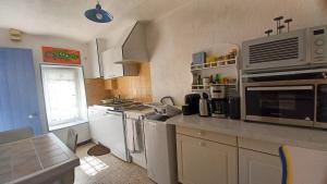 a kitchen with stainless steel appliances and a window at La cigale in Gourdon