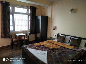 een hotelkamer met een bed en een raam bij Sagarmatha Homestay in Darjeeling