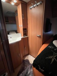 Camping Alex في Cadenazzo: غرفة صغيرة بها سرير ومغسلة