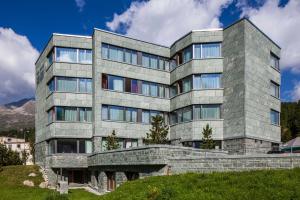 a large stone building on top of a hill at Sport & Wellnesshotel San Gian St. Moritz in St. Moritz