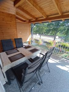 una mesa de madera y 2 sillas en el patio en Szemes Apartman Balaton, en Balatonszemes