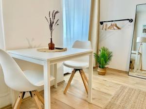 einen weißen Tisch und zwei weiße Stühle in einem Zimmer in der Unterkunft Stylish Studio near Center in Wien