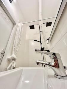 ein weißes Badezimmer mit einem Waschbecken und einem Spiegel in der Unterkunft Stylish Studio near Center in Wien