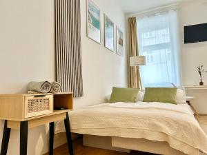 Schlafzimmer mit einem Bett, einem Tisch und einem Fenster in der Unterkunft Stylish Studio near Center in Wien