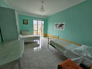 een kamer met 2 bedden in een kamer met groene muren bij Casa delle Calle in Torre Annunziata