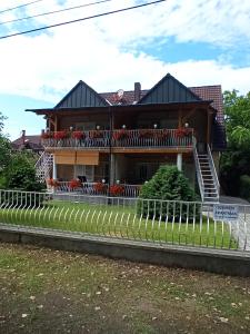 a house with a balcony with flowers on it at Szemes Apartman Balaton in Balatonszemes