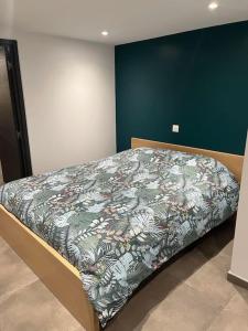 ein Schlafzimmer mit einem Bett mit einer Decke darauf in der Unterkunft maison cosy centre-ville in Lens