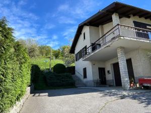 a large white house with a balcony on top of it at Sunny Hill Apartment in Ilirska Bistrica