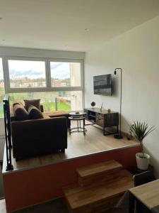 un soggiorno con divano e una grande finestra di maison cosy centre-ville a Lens