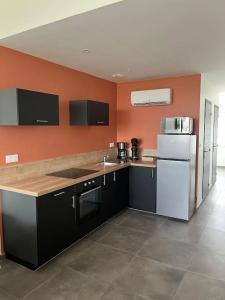 a kitchen with orange walls and a white refrigerator at maison cosy centre-ville in Lens