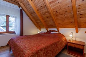 a bedroom with a bed and a wooden ceiling at Vila Banga in Nida