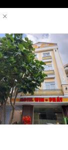 a building with a tree in front of it at MOTEL WIN - PHÁT in Bien Hoa