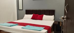 a bedroom with a large bed with red and white pillows at HOTEL AYODHYA PAYING GUEST in Ayodhya