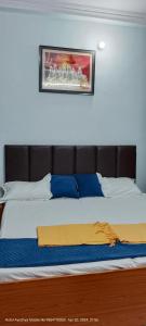 a bed in a bedroom with a picture on the wall at HOTEL AYODHYA PAYING GUEST in Ayodhya