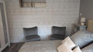 a bedroom with two chairs and a bed at Opale Baie in Berck-sur-Mer