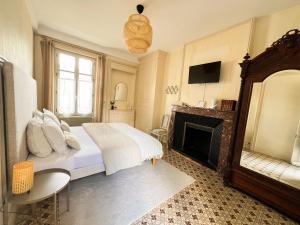 1 dormitorio con 1 cama y chimenea en Closerie la Fontaine, en Savigné-sur-Lathan