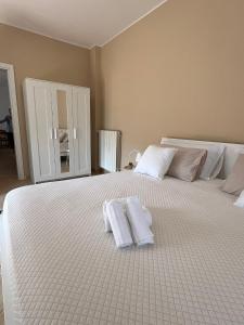 - une chambre avec un grand lit blanc et des serviettes dans l'établissement Villa Maria Palese, à Bari