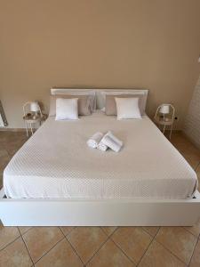 Villa Maria Palese في باري: سرير ابيض كبير عليه منشفتين