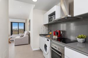 a kitchen with a washer and dryer in a apartment at Luxe Appartement Lo Pagan - San Pedro del Pinatar 850m from Beach Aldea Del Sol in San Pedro del Pinatar