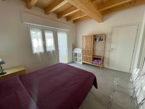 a bedroom with a bed with a purple blanket at RESIDENCE PACE - Agenzia Cocal in Caorle
