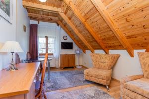 sala de estar con techos de madera, mesa y sillas en Vila Banga, en Nida