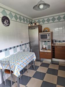 a kitchen with a table and a refrigerator at Casina verde manzana in Villaviciosa