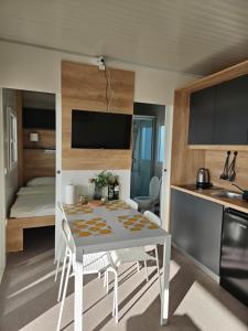 a kitchen and dining room with a white table and chairs at Mobile home Jadre I in Pakoštane