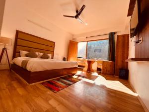 a bedroom with a bed and a ceiling fan at Solank Hotel & Cafe in Amritsar
